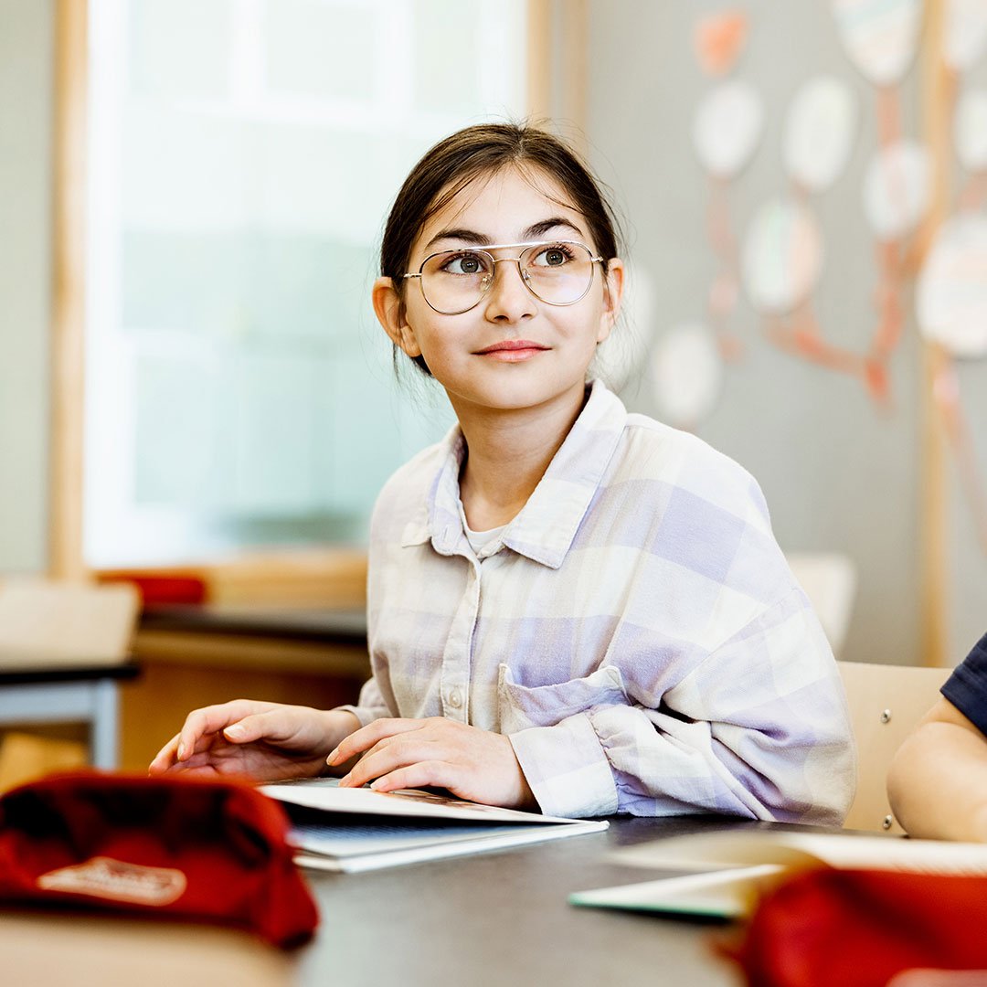 Elev på Innovitaskolan sitter vid sin bänk i klassrummet.
