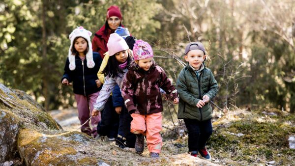 Glada barn är ute i skogen en härlig vårdag.